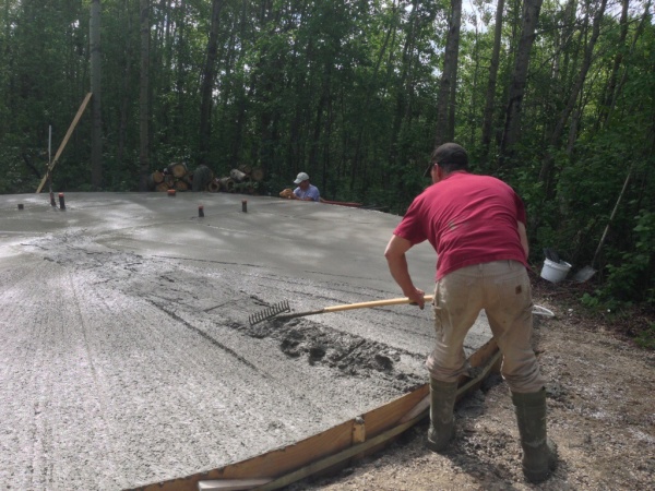 Hard working buddy screeding fresh cement.