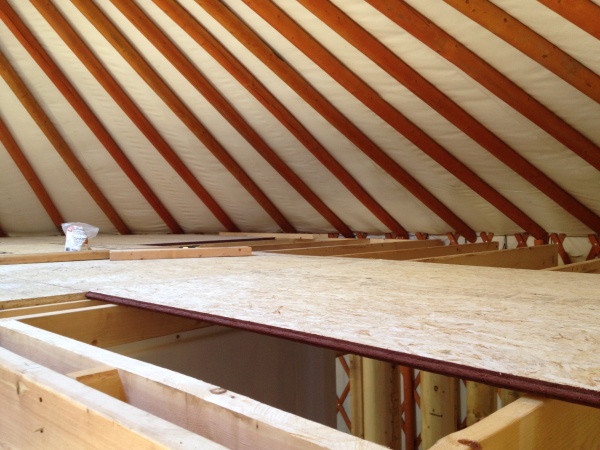 Loft floor going down. The floor, like the interior walls, does not meet the yurt walls.  A 4 inch gap has been left to allow air to move freely
