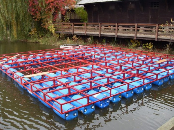 Steel framework is supported by plastic barrels.