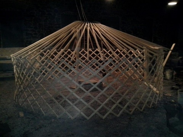 Wood roof poles, metal pins, and a metal roof ring. It had a tendency to spiral down and in on itself.  The roof is precariously balanced on three pol