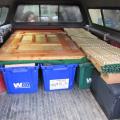 Ger in the truck heading out camping in Oregon's High Desert, door, and walls on top of bins of firewood, stove, and tools'